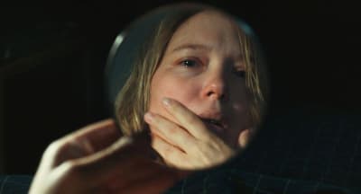 Une femme se regarde dans un miroir